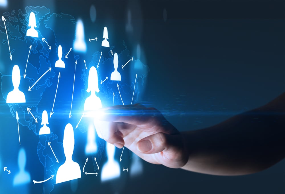 Female finger touching a beam of light surrounded by portraits and a world map behind it