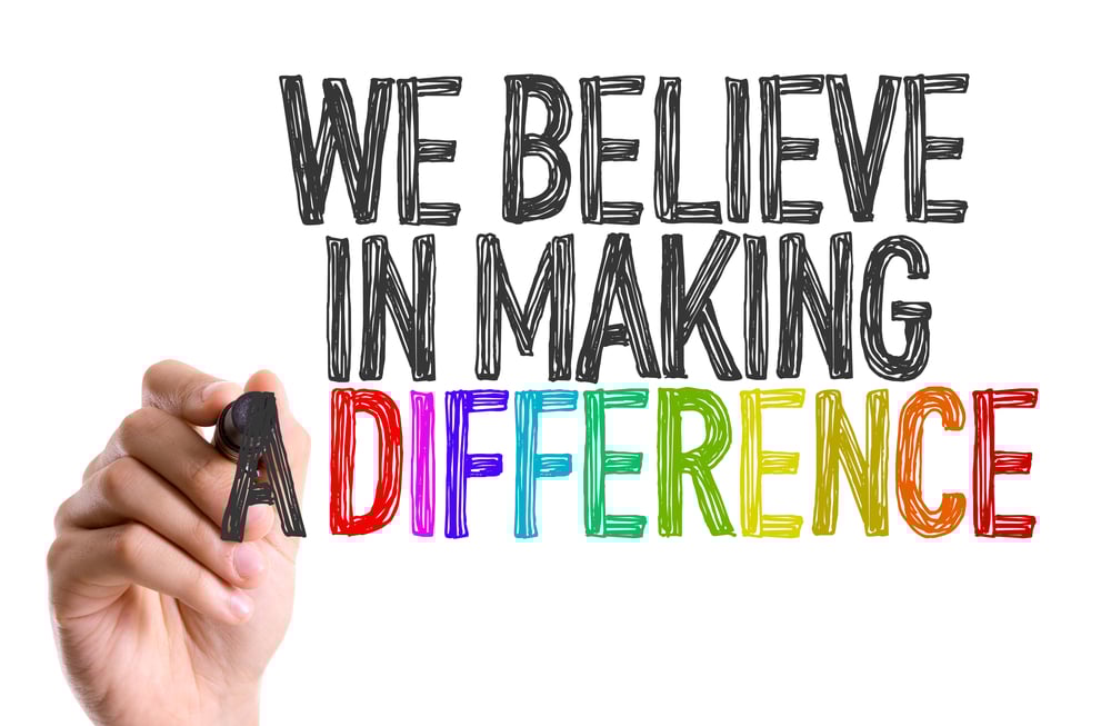 Hand with marker writing We Believe in Making a Difference-1