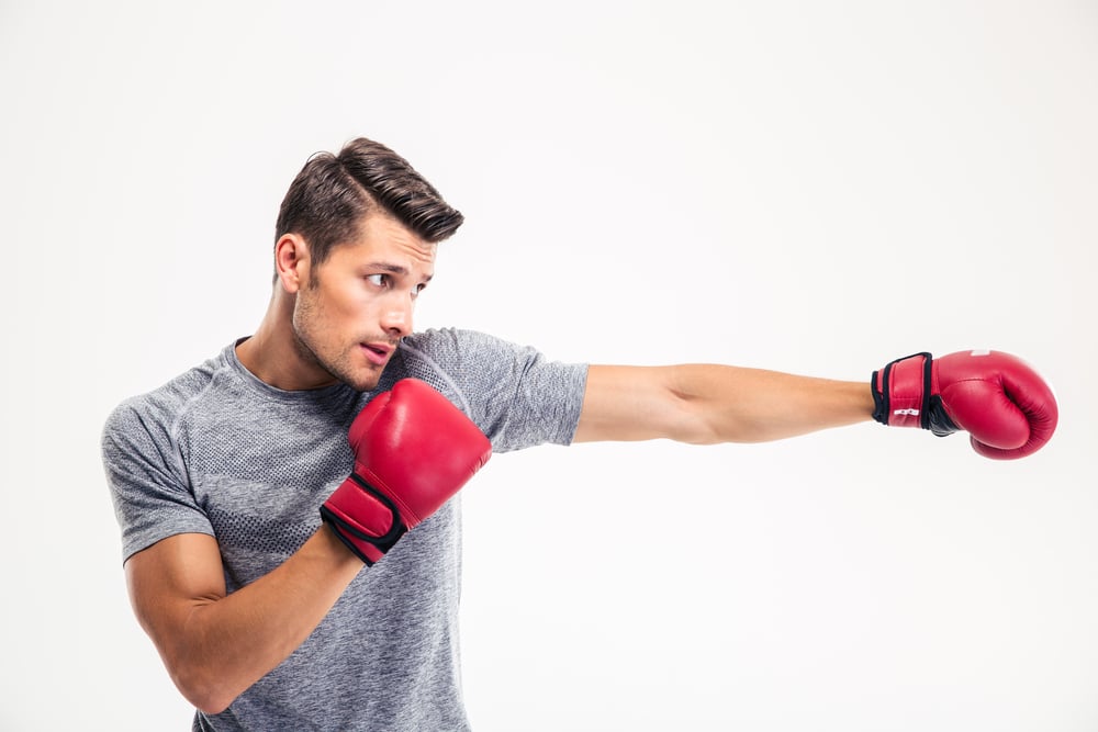 Side view portrait of a handsome man boxing isolated on a white background